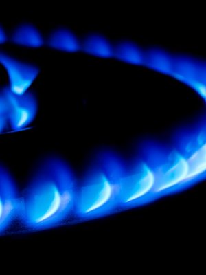 blue flames from a double ring giant gas stove in the dark